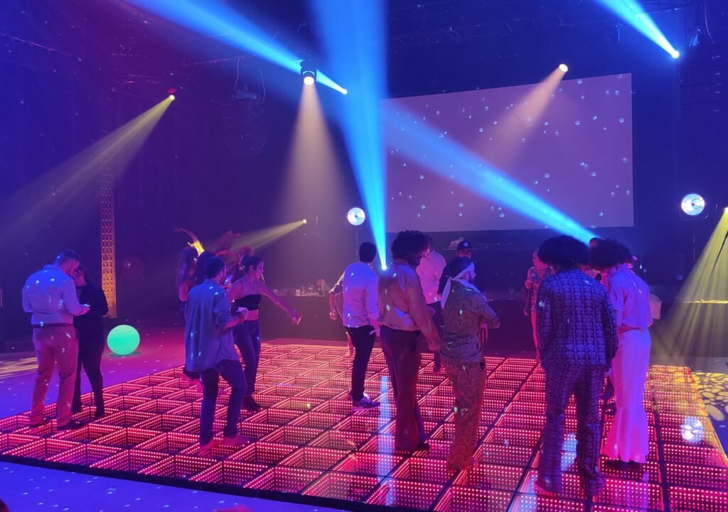 Invités dansant sur une piste de danse lumineuse LED sous des jeux de lumière